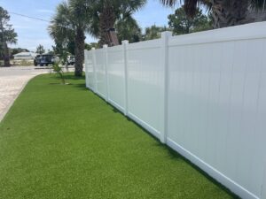 A white vinyl privacy fence installed along a manicured lawn by Superior Fence & Rail of North Shore in Gulfport, MS.