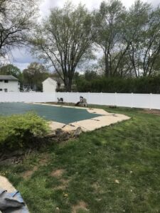 A white vinyl privacy fence enclosing a backyard pool area by The Fence Dr. in Scranton, PA.