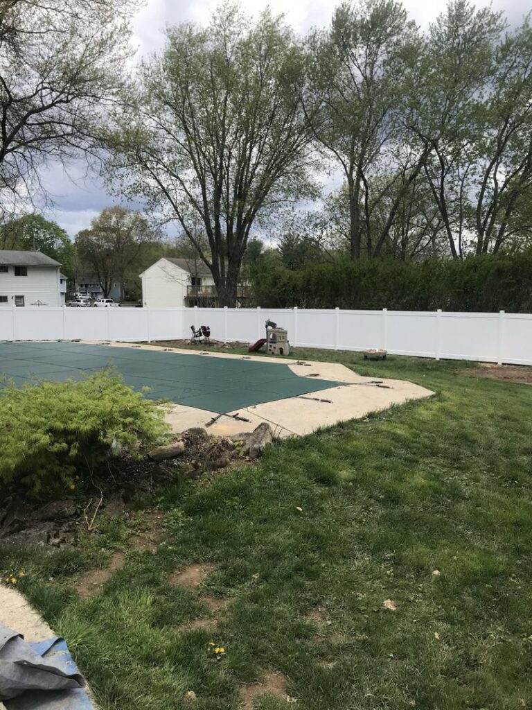 A white vinyl privacy fence enclosing a backyard pool area by The Fence Dr. in Scranton, PA.