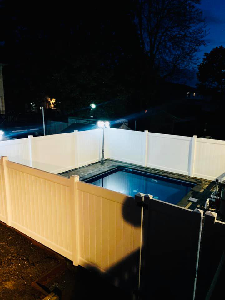 A white vinyl privacy fence installed around a swimming pool by Elite Ornamental Fence LLC in Paterson, NJ.