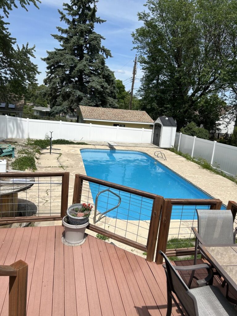A white vinyl privacy fence installed around a residential swimming pool by Schumacher Fencing, LLC in Columbus, NE.