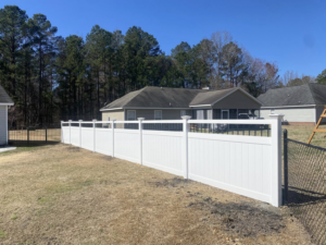 A newly installed white vinyl privacy fence with decorative accents by Renegade Fencing, LLC in Jacksonville, NC.