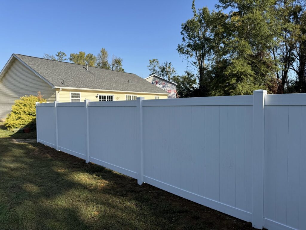 A pristine white vinyl privacy fence installed around a residential property by ACE and Sons Fence Company in Evansville, IN.