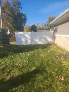 A newly installed white vinyl privacy fence in a residential backyard by Cameron Fence Builders in Indianapolis, IN.