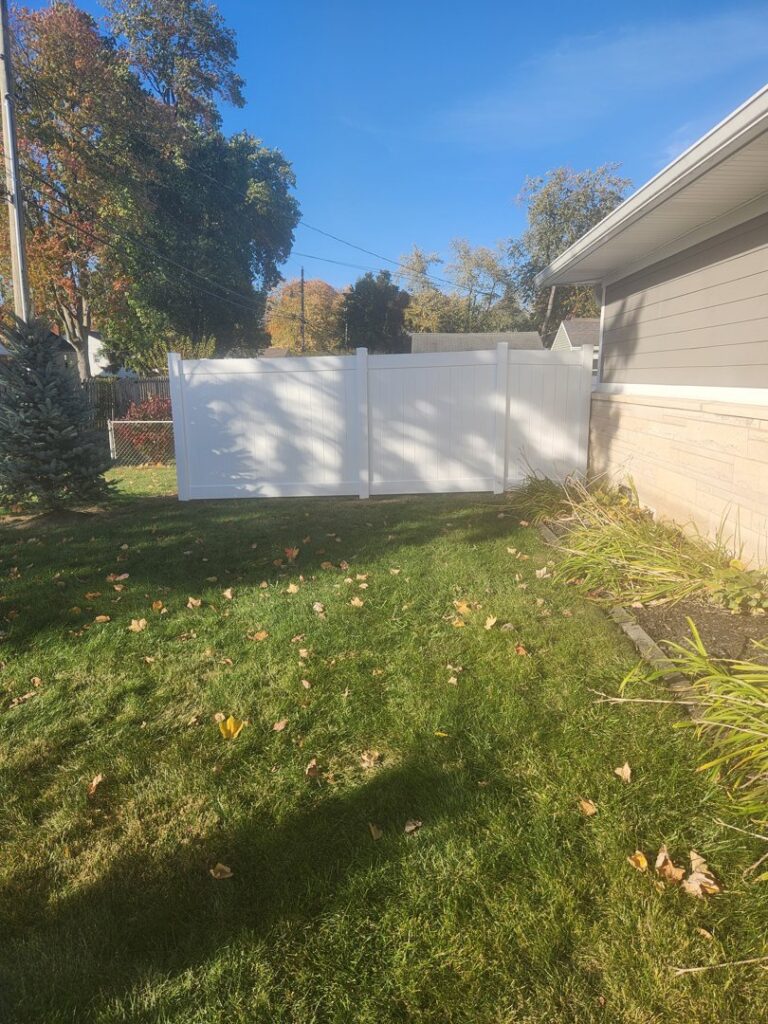 A newly installed white vinyl privacy fence in a residential backyard by Cameron Fence Builders in Indianapolis, IN.