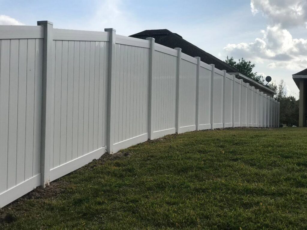 A long, pristine white vinyl privacy fence installed around a residential property by Fencing & Railing 2 Corp in Orlando, FL.