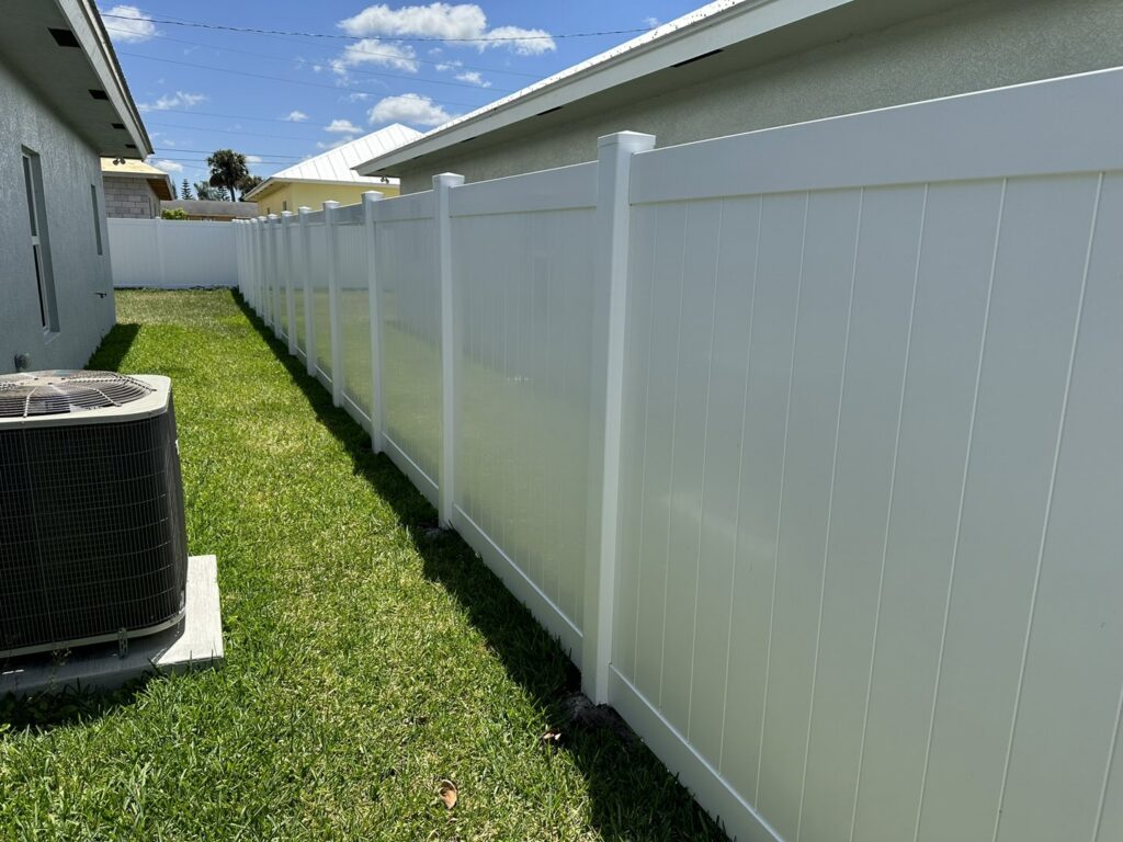 A pristine white vinyl privacy fence running alongside a residential property, installed by Inovation Fence in Fort Worth, TX.