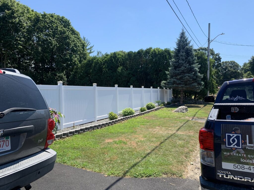 White vinyl privacy fence installed in a residential area by Louis Fence installations & repairs in Fall River, MA