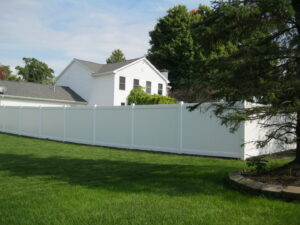 A long white vinyl privacy fence surrounding a residential property by Metrofence in Grand Rapids, MI.