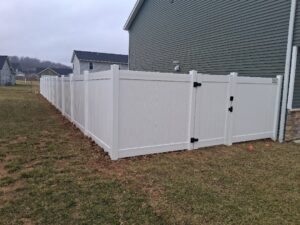 A white vinyl privacy fence with a gate installed in a residential backyard by Morton Fence Solutions LLC in Indianapolis, IN.