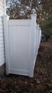 A white vinyl privacy fence installed along the side of a house by Fences & Landscape Inc in Little Rock, AR.