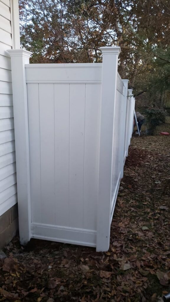 A white vinyl privacy fence installed along the side of a house by Fences & Landscape Inc in Little Rock, AR.