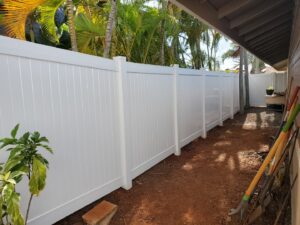 A white vinyl privacy fence installed along a narrow side yard by Redmond Valleywide - Hawaii's Fence Company in Kapolei, HI