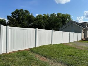 A pristine white vinyl privacy fence installed along a property line by Sunrise Fences in Goose Creek, SC.