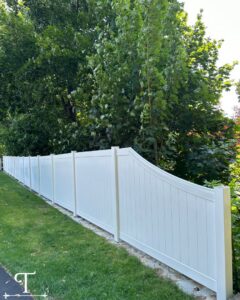A long white vinyl privacy fence with a decorative curved top, installed by Teto's Fence Installation in Bridgeport, CT.