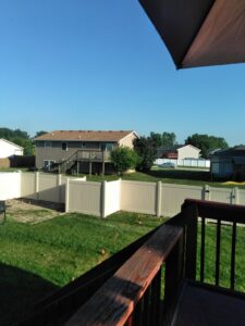 A white vinyl privacy fence under construction in a residential backyard by AmeriDream Fence & Deck in Joliet, IL.
