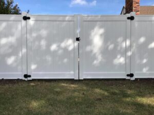 A white vinyl privacy fence with a gate installed by ProScape Outdoor Construction LLC in Norman, OK.