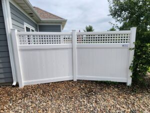 A white vinyl privacy fence with a lattice top section installed next to a home by MN Mike's Fence and Repair in Lakeville, MN.