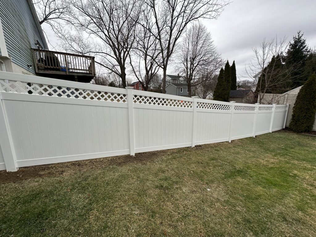 A white vinyl privacy fence with a decorative lattice top installed by Quality Fence Inc. in Peekskill, NY.