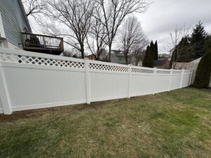 A white vinyl privacy fence with a decorative lattice top installed by Quality Fence Inc. in Peekskill, NY.