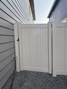 A white vinyl privacy gate installed between two residential homes by Crows Quality Fencing in Spokane Valley, WA.