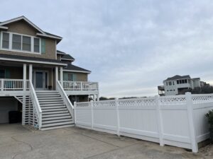 A white vinyl privacy fence with a decorative lattice top installed by Sea Level Fence in Harbinger, NC