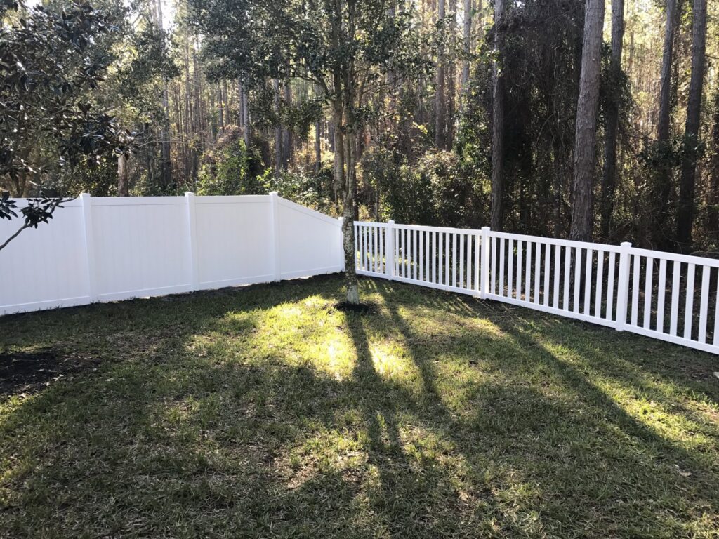 A combination of white vinyl privacy and picket fencing installed in a backyard by Big Jerry's Fencing of Boise ID in Holly Springs, NC.