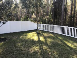 A combination of white vinyl privacy and picket fencing installed in a backyard by Big Jerry's Fencing of Boise ID in Holly Springs, NC.
