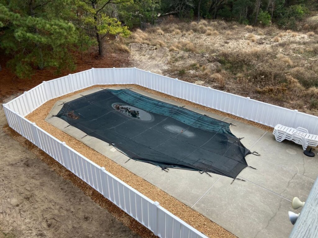 An aerial view of a white vinyl privacy fence enclosing a pool area by Sea Level Fence in Harbinger, NC