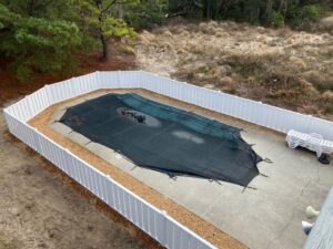 An aerial view of a white vinyl privacy fence enclosing a pool area by Sea Level Fence in Harbinger, NC
