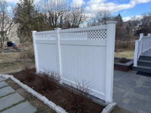 A white vinyl privacy screen fence installed next to a patio by Quality Fence Inc. in Peekskill, NY.