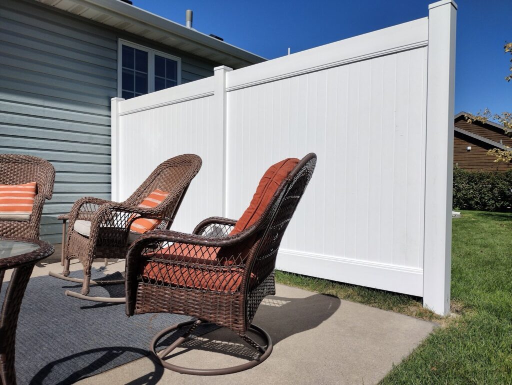 A white vinyl privacy screen installed next to a patio by Aces Deck and Fence, LLC in Fargo, ND.