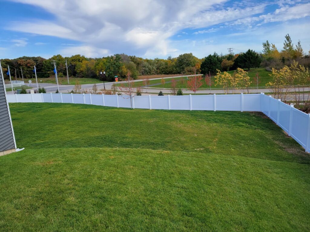 A white vinyl fence installed along a residential property line by Fence Connection, Inc. in Elgin, IL.