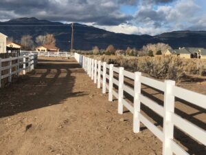 A long white vinyl ranch-style fence installed along a dirt road by Finest Fence in Simi Valley, CA.