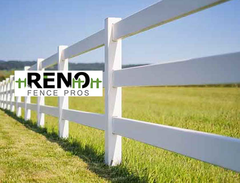 A newly installed white vinyl ranch fence stretching across a green field by Reno Fence Pros in Reno, NV.