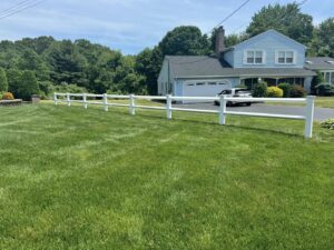 A white vinyl ranch-style fence installed in a residential front yard by Select Fence & Guardrail in North Haven, CT.