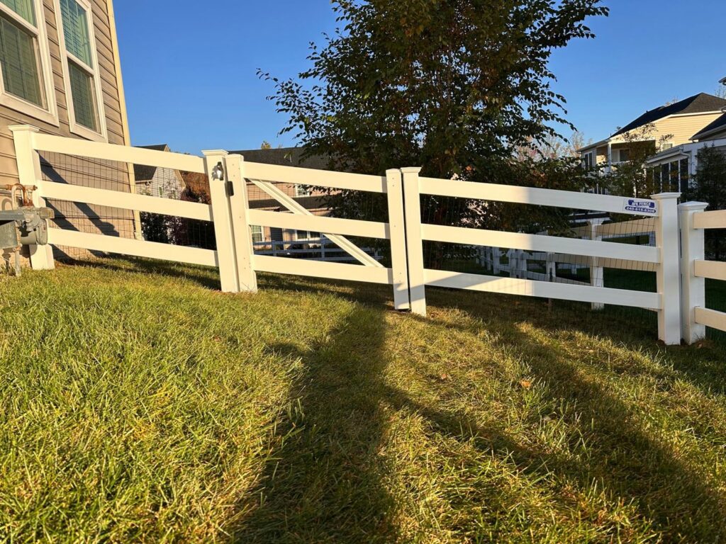 A white vinyl ranch-style fence with integrated wire mesh and a matching gate, installed by AFK FENCE LLC in Waldorf, MD.