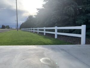 A long white vinyl ranch-style fence installed along a property line by Idaho Falls Fencing in Idaho Falls, ID.