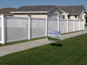 A white vinyl semi-privacy fence installed along a residential sidewalk by Schumacher Fencing, LLC in Columbus, NE.