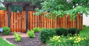 A long white vinyl split-rail fence installed on a sloped grassy area by McDaniels Fencing in Huntington, WV.