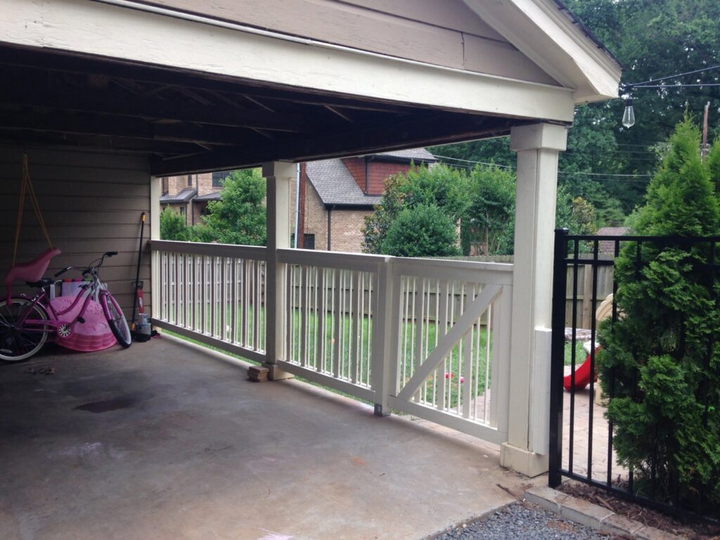 A white wooden railing and gate installed under a carport by Timber Fencing in Charlotte, NC.