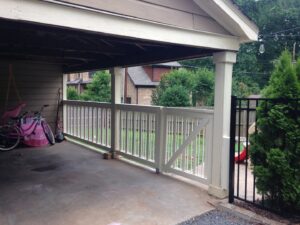 A white wooden railing and gate installed under a carport by Timber Fencing in Charlotte, NC.