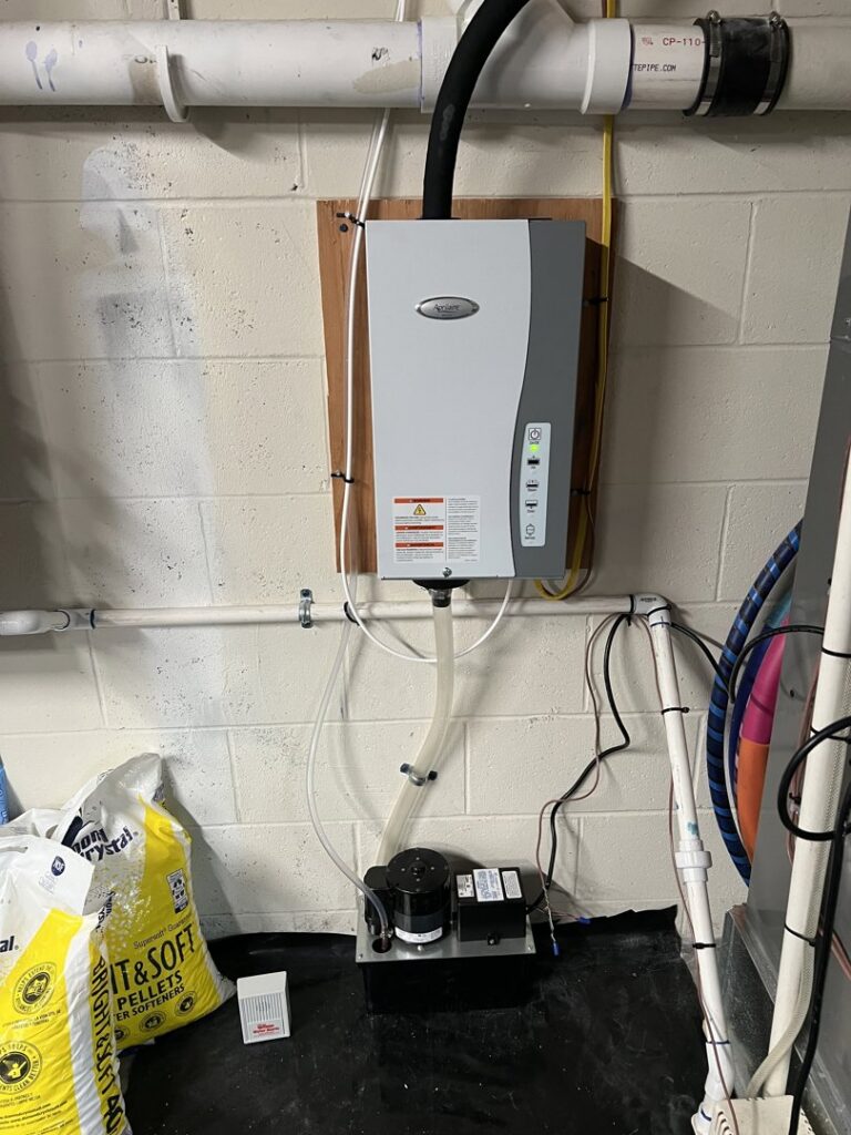 A wall-mounted whole-home humidifier system with a drainage pump, installed by Prime Home HVAC for improved indoor air quality in York, PA.