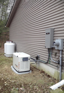 A Generac whole-house generator and propane tank installed next to a residential building by Moser Electric in Wisconsin Rapids, WI.