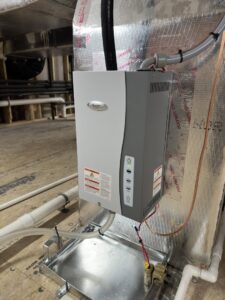 A newly installed whole-house humidifier unit attached to HVAC ductwork by Chad Byers - Edge Guys Heating & Cooling in Carmel, IN
