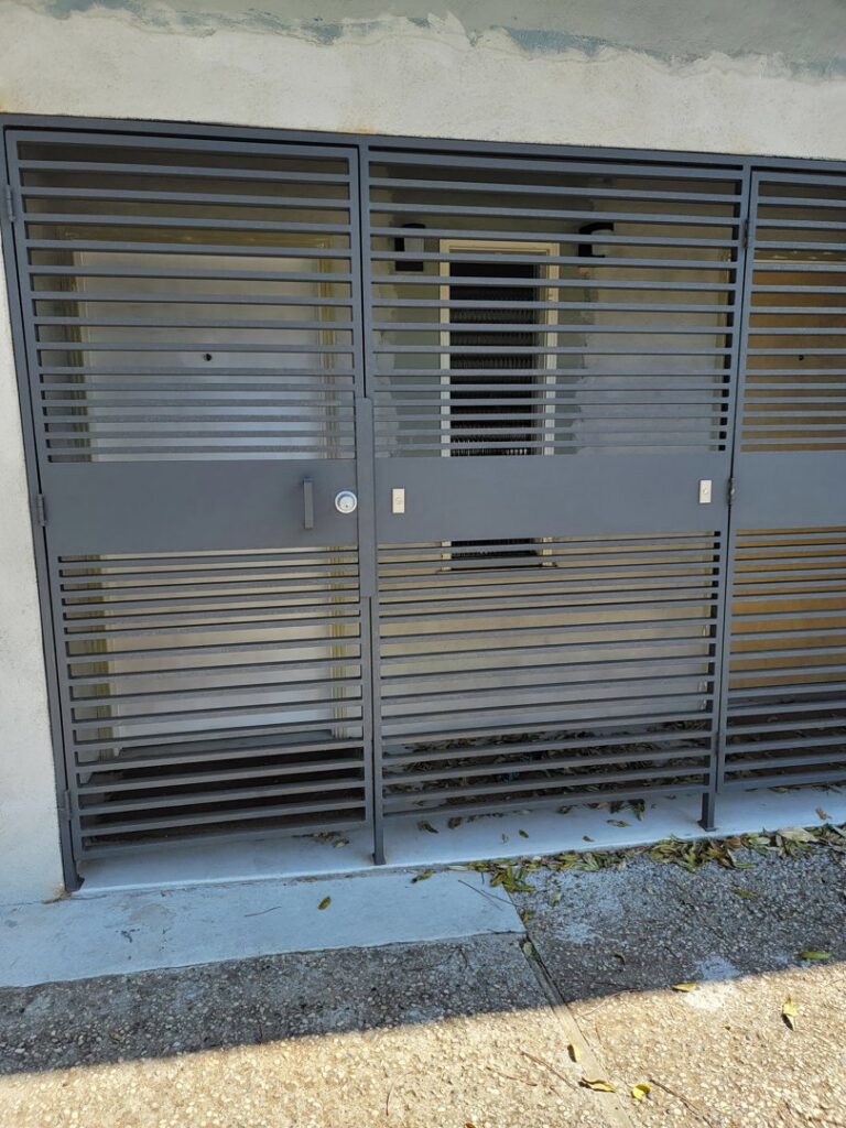 A wide black metal security gate with horizontal bars covering a large entrance, installed by Fierro Iron Works Inc. in San Francisco, CA.