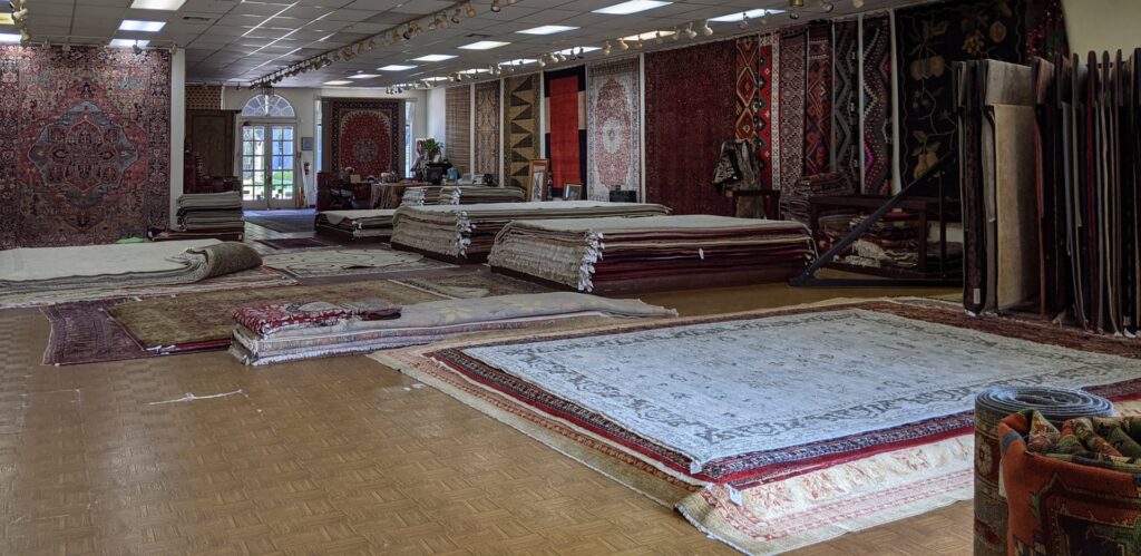 A wide variety of rugs displayed on the floor in the showroom of Woven Treasures, Inc in Mobile, AL.