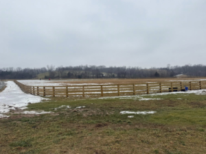 A wide view of newly installed wooden farm fencing across a large property by Richards Fencing in Lynnville, TN