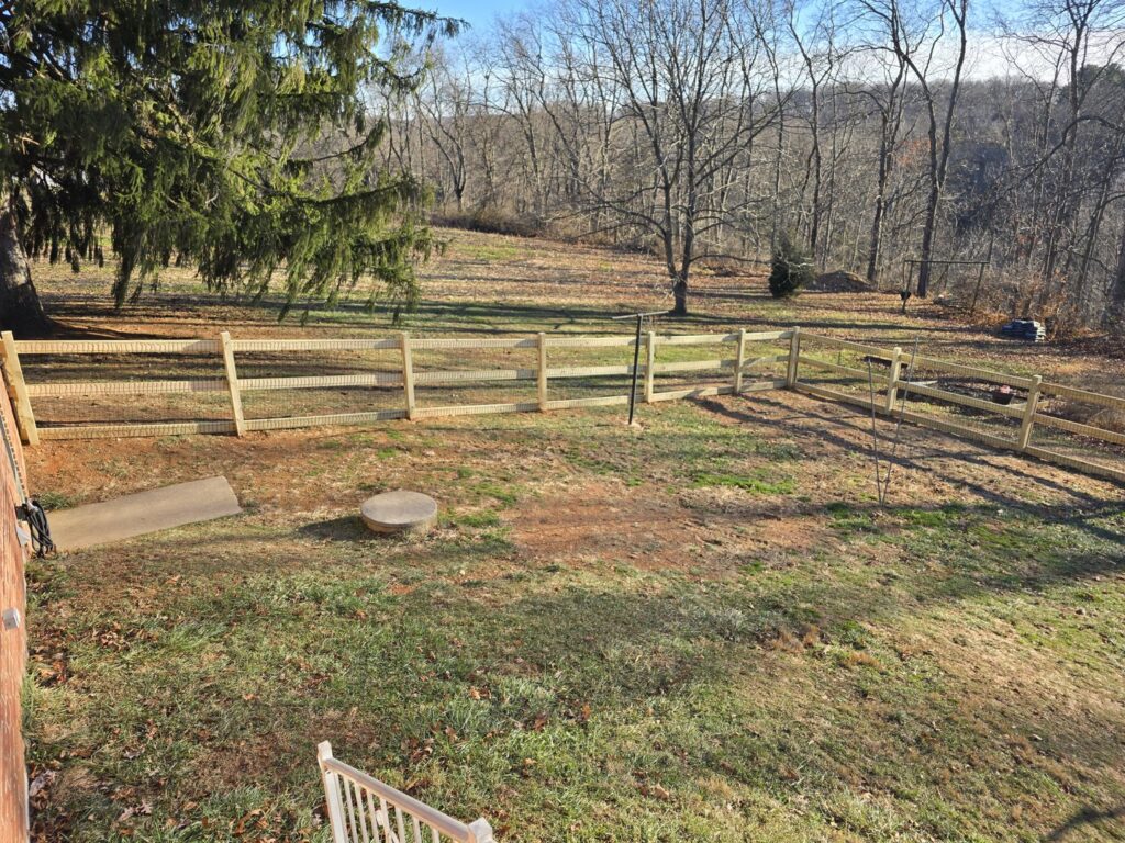 A wide view of a newly installed wooden split-rail fence with wire mesh in a rural setting by Future Solutions Fence Supply in York, PA