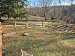 A wide view of a newly installed wooden split-rail fence with wire mesh in a rural setting by Future Solutions Fence Supply in York, PA